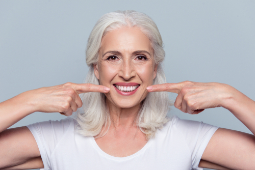 woman pointing at her smile