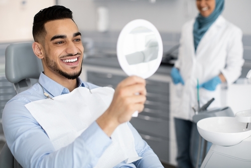 man admiring his smile after getting veneers