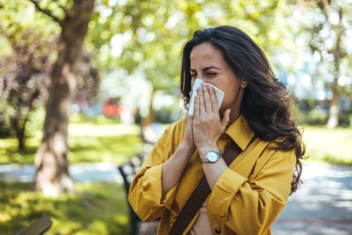 woman blowing her nose into a tissue